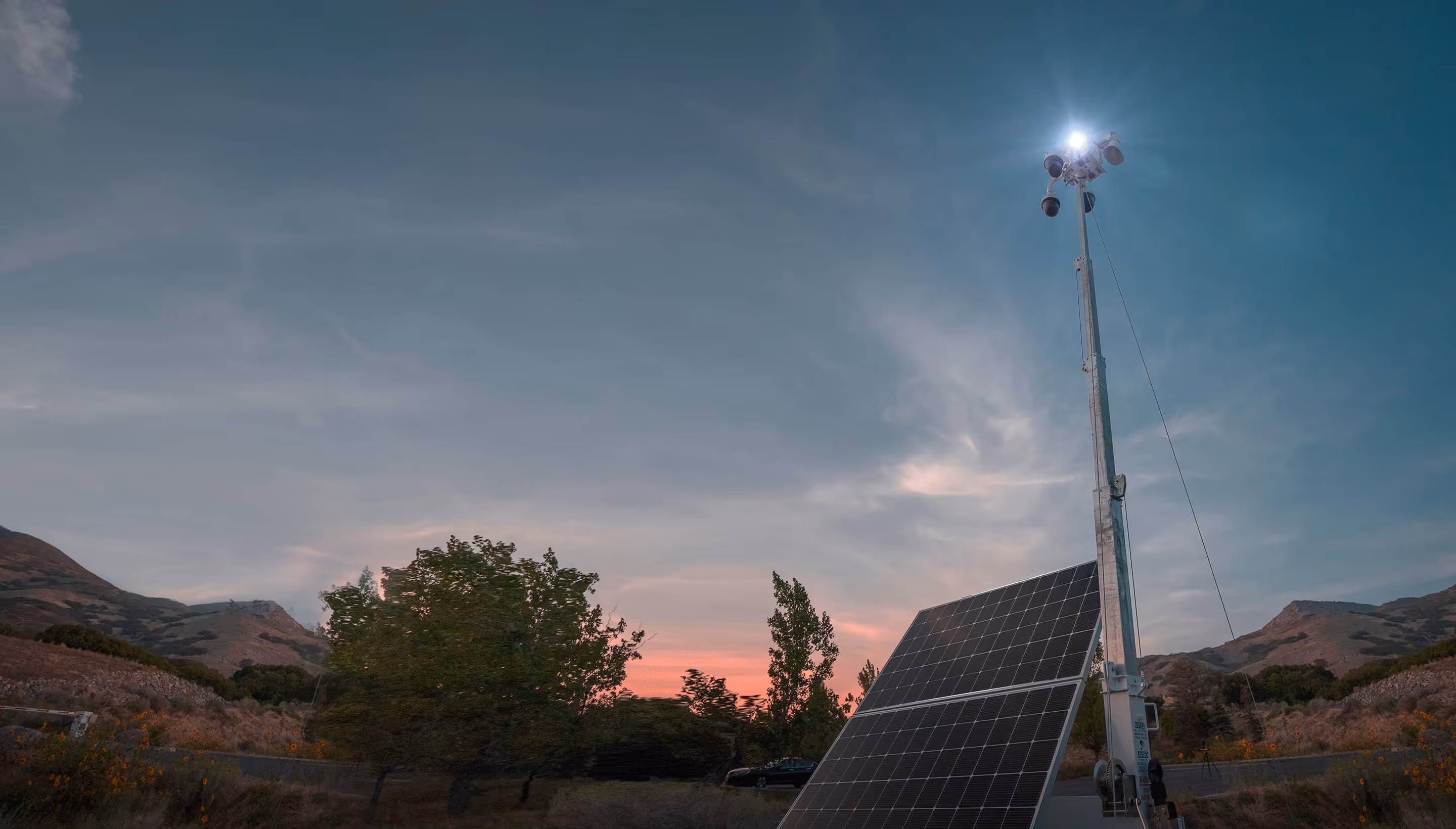 Solar security camera trailer monitoring an outdoor site at dusk